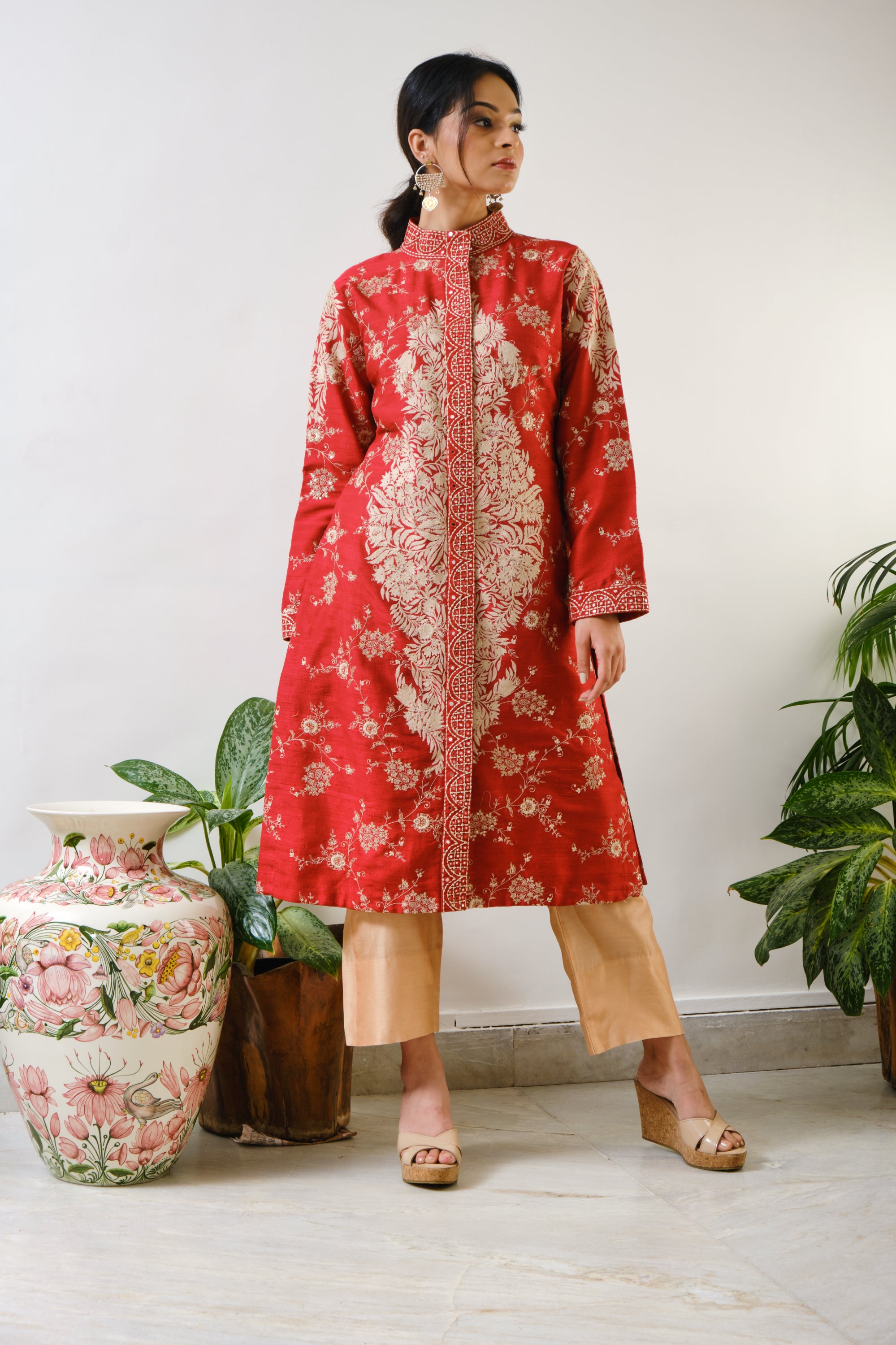 This is a red, chinese collared, front open, full sleeved jacket in rawsilk in mirror & threadwork & beautiful delicate jaal embroidery allover with ari motif in the front centre & sleevesRed embroidered Jacket only with ari motif
